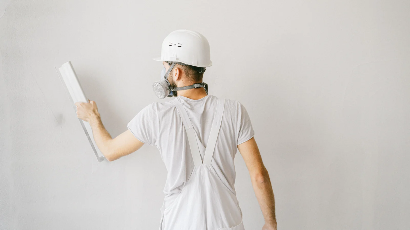 Plaster professional smoothing a wall during loose and bulging stucco repair